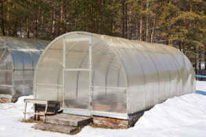 Quonset greenhouse in the snow covered with clear fiberglass panels